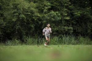 gelukkig schattig klein meisje dat op het gras in het park loopt foto