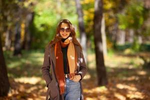 mooie jonge vrouw loopt in het herfstbos foto