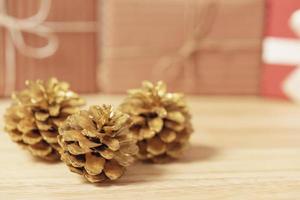 gouden dennenappels schitterden kerst- en geschenkdoosdecoratie op houten tafelachtergrond. ruimte kopiëren.