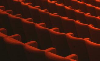 rijen van oranje stoelen in een auditorium foto