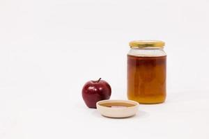 Rode appel en pot honing kom met honing geïsoleerd op een witte achtergrond