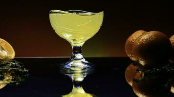 oranje alcohol cocktail in een glas Aan kleurrijk muur achtergrond. voorraad klem. verkoudheid verfrissend drinken en een bar teller met oranje vruchten. foto