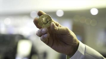 zakenman hand- Holding gloeiend bitcoin teken. voorraad. virtueel geld concept en financieel groei concept Aan tabel achtergrond. hand- van een zakenman Holding een munt bitcoin foto