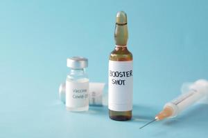 booster shot dosis coronavirus vaccin en spuit op blauw foto