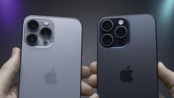 Verenigde Staten van Amerika, nieuw york - september 15, 2023. iphone ontwerp vergelijking. actie. Mens is Holding laatste versies van iphones 14 en 15 pro in handen. extern vergelijking van ontwerp van laatste iphones 14 en 15 pro foto