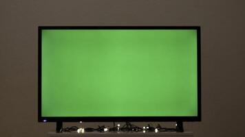 groen TV scherm met knippert guirlande. concept. slinger knippert Aan achtergrond van groen TV in kamer. groen scherm TV in leeg kamer met feestelijk atmosfeer foto