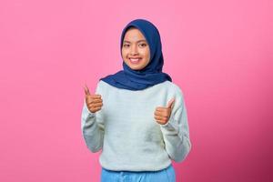 portret van vrolijke jonge aziatische vrouw die duimen omhoog of goedkeuringsteken toont
