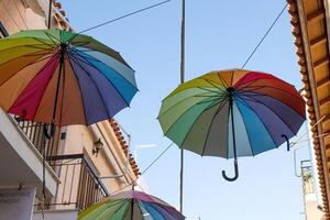 kleurrijk paraplu's hangende in de lucht Aan de straat in aegina, Griekenland foto