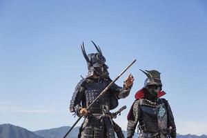 miyajima, japan, 10 oktober 2016 - niet-geïdentificeerde mannen verkleed als samoerai bij het itukushima-heiligdom op het eiland muyajima, japan. heiligdom is UNESCO-werelderfgoed sinds 1996. foto