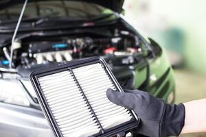 hand- een Mens controleren lucht filter van auto in de motor kamer onderhoud concept foto