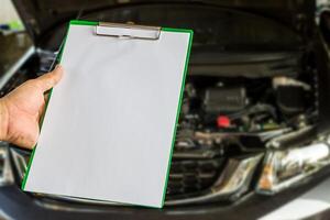 hand- een Mens houden controleren vel papier voor onderhoud concept van auto foto