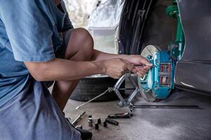 huis onderhoud auto concept een Mens verwijderen bout van remklauw rem in rem stootkussen controleren en eenvoudig onderhoud foto
