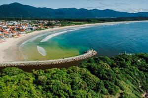 strand met rivier- en oceaan in Brazilië. antenne visie van barra da Lagoa dorp in florianopolis foto