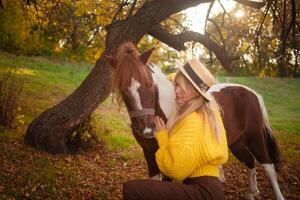 mooi screensaver, achtergrond, herfst Woud, vrouw en pony in natuur, concept van liefde, vrede en goedheid. knuffelen. foto