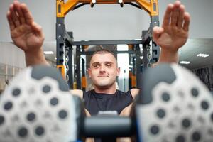 trainer uitvoeren een oefening Aan de simulator in de Sportschool, Vrolijk, lachend. schattig trainer voert een individu geschiktheid les, opleiding, gewicht verlies. foto