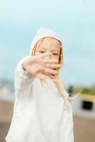 mooi en blond meisje covers haar gezicht met haar hand. hou op hand- teken foto