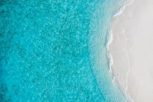 zomer zeegezicht mooie golven, blauwe zeewater in zonnige dag. bovenaanzicht van drone. zee luchtfoto, verbazingwekkende tropische natuur achtergrond. prachtige heldere zee met spattende golven en strandzandconcept foto