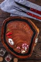 hout hars snijplank met kruiden en barbecue vork en mes op houten tafel - bovenaanzicht. foto