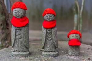 3 weinig monnik standbeelden met rood gebreid hoeden en sjaals Bij de rinno-ji tempel in sturen, Japan foto