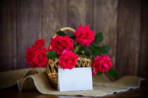 boeket van mooi rood rozen in een mand Aan tafel foto