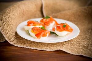 helften van gekookt eieren met stukken van gezouten Zalm foto