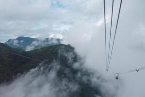 kabel auto draagt passagier in beweging Aan de berg tussen de mistig in bewolkt dag Bij sapa foto