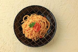 pasta spaghetti bolognese in zwart bord Aan room getextureerde achtergrond. foto