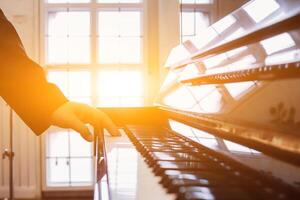 zacht focus en vervagen, de pianist is vaststelling en aanpassen de geluid van de piano correct en precies zo dat de praktijk en prestatie van de piano zullen worden melodieus en zonder fouten. foto