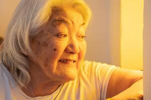 senior volwassen vrouw op zoek uit de venster en lachend. helder omgeving. foto