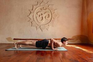 Mens in chaturanga houding in yoga studio. gezond levensstijl foto