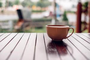 heet latte koffie kop Aan hout tafel foto