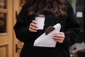 vrouw Holding een mok van koffie en havermout koekjes in haar handen foto