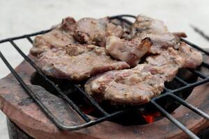 drie stukken van gegrild varkensvlees Aan een rubber grillen. plaats Aan de houtskool fornuis. foto