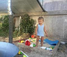 mooie baby in kinderzandbak poseren fotograaf in de buurt van zandbak foto