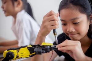 inventief kinderen leren Bij huis door codering robot auto's en elektronisch bord kabels in stang. construeren robot auto's Bij huis foto