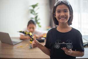 inventief kinderen leren Bij huis door codering robot auto's en elektronisch bord kabels in stang. construeren robot auto's Bij huis foto