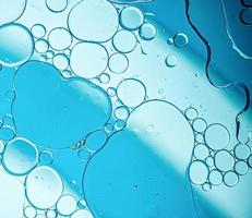 blauwe oliebellen in water met abstract patroon