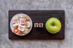 snoep versus appel bovenaanzicht op donkere achtergrond foto
