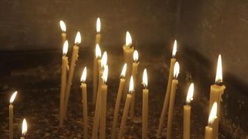 verlichting een kaars met een bij elkaar passen naar krijgen een romantisch kaarslicht. verbazingwekkend andles en kandelaars zijn Aan de tafel. blijven lichten met de vredig achtergrond van religieus ceremonie. foto