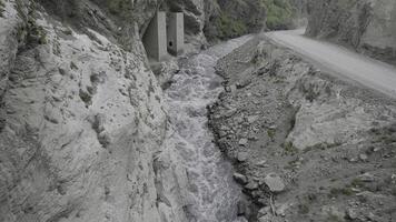 een krachtig stroom van water is geperst tussen de zijden van de rotsen. actie. antenne visie van de rivier- vloeiende in een kloof tussen bergen. foto