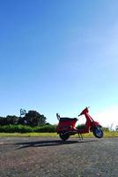 vintage scooter stands en blauwe lucht foto