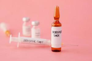 booster shot dosis coronavirusvaccin en spuit op roze foto