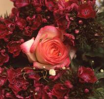 een roos is in een boeket van rood bloemen foto