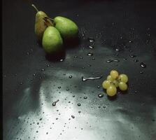 een tafel met druiven en peren Aan het foto