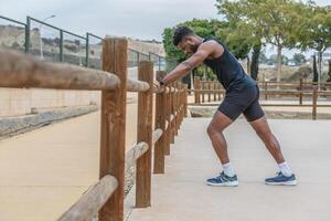 vastbesloten zwart atleet opwarming omhoog voordat training foto