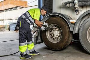 monteur aanscherping wiel van vrachtauto in werkplaats foto