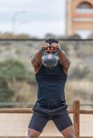 fit sportman het uitvoeren van kettlebell schommel oefening gedurende training foto