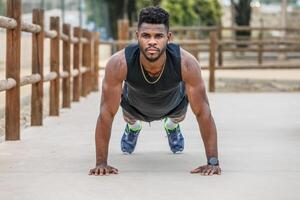 sterk sportman aan het doen plank in stad park foto