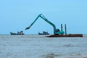 machines zijn baggeren zand in de zee. foto