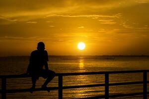 silhouet van een eenzaam Mens Bij zonsondergang foto